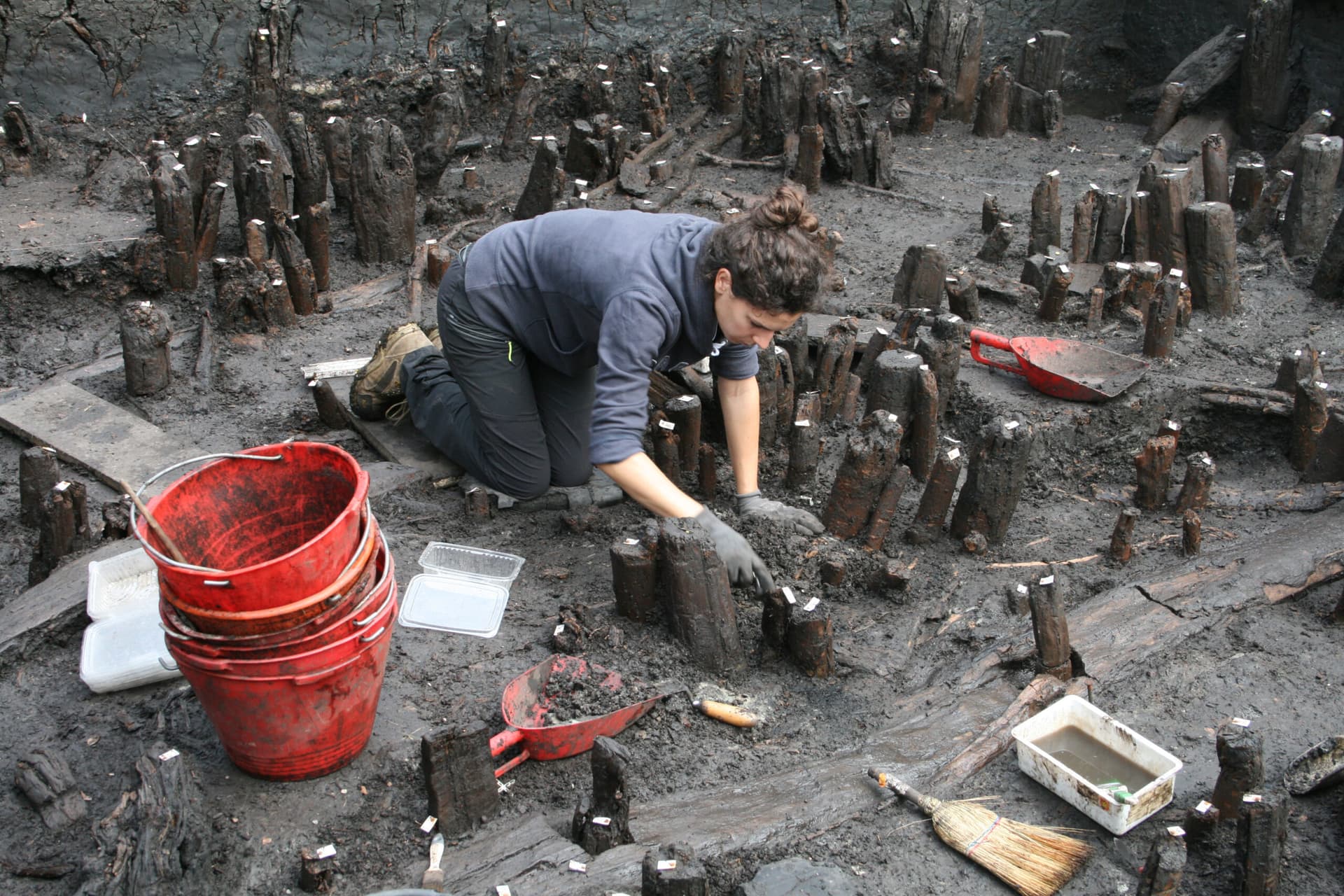 Immagine di archeologa che esamina gli scavi
